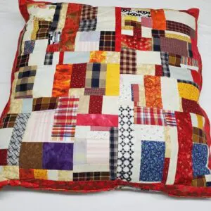 Patchwork quilted pillow on white bed