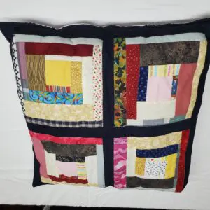 Colorful patchwork pillow with black trim.
