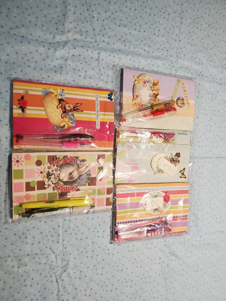 Assorted decorative notebooks and pens on fabric.