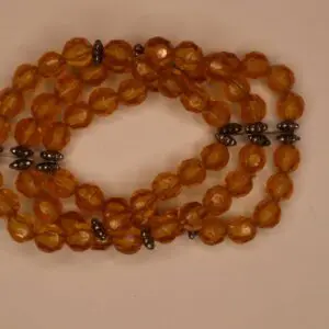 Amber beaded necklace with decorative metal accents.