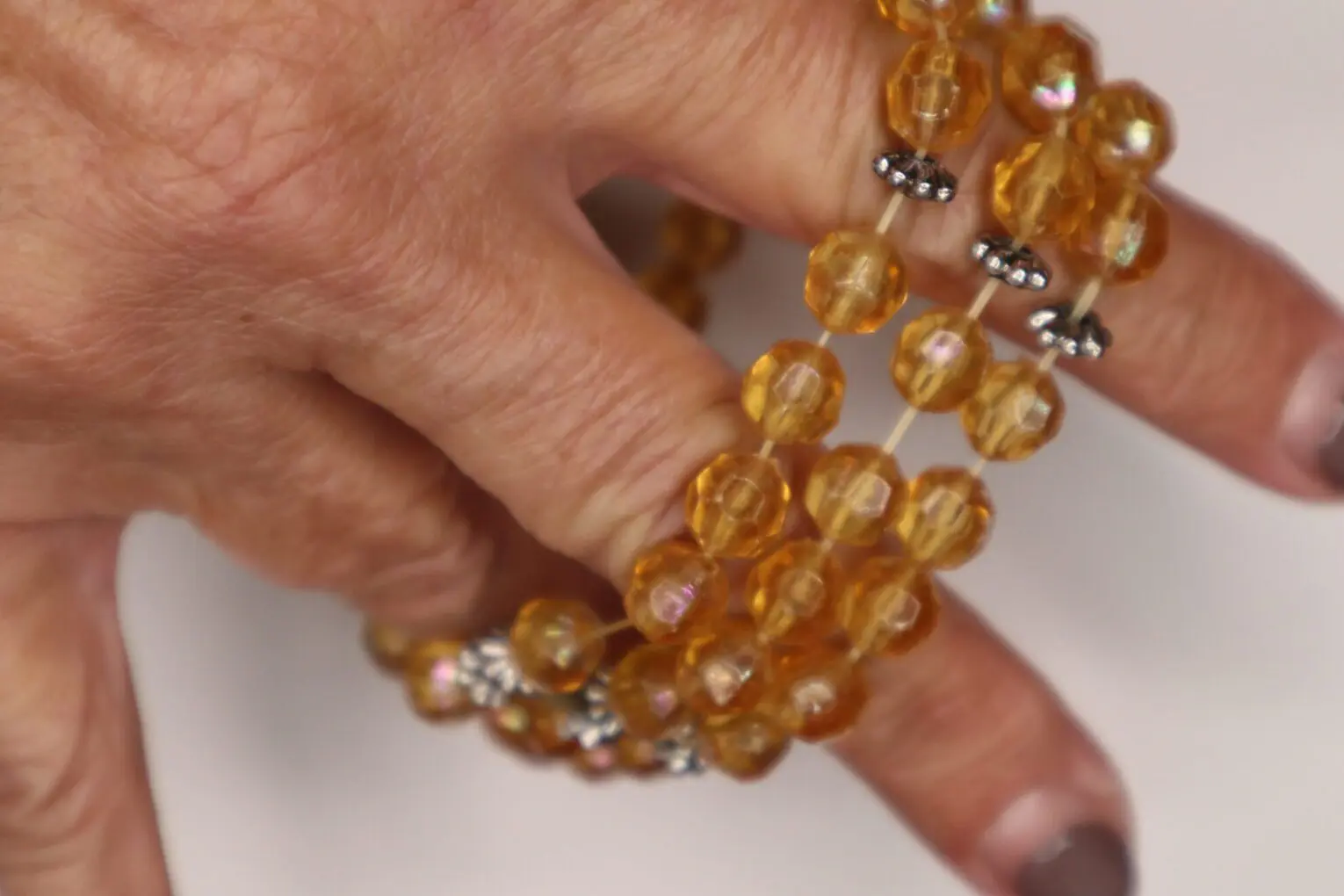 Amber beaded necklace with silver accents displayed.