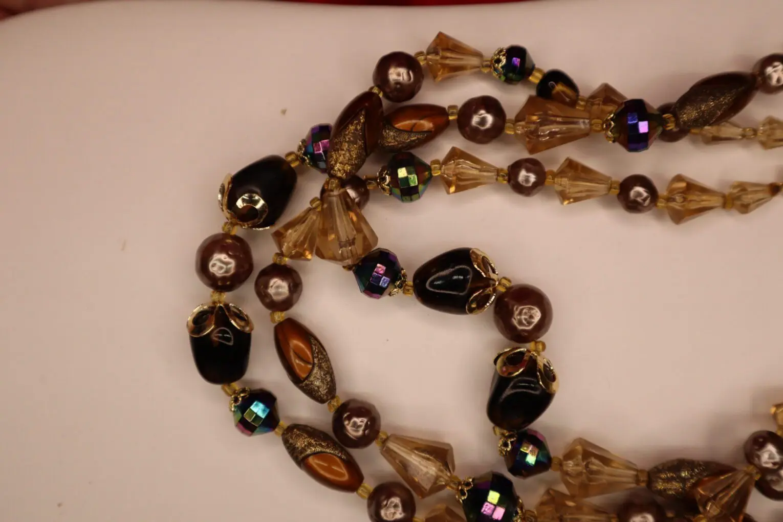 Colorful beaded necklace with various shapes displayed.