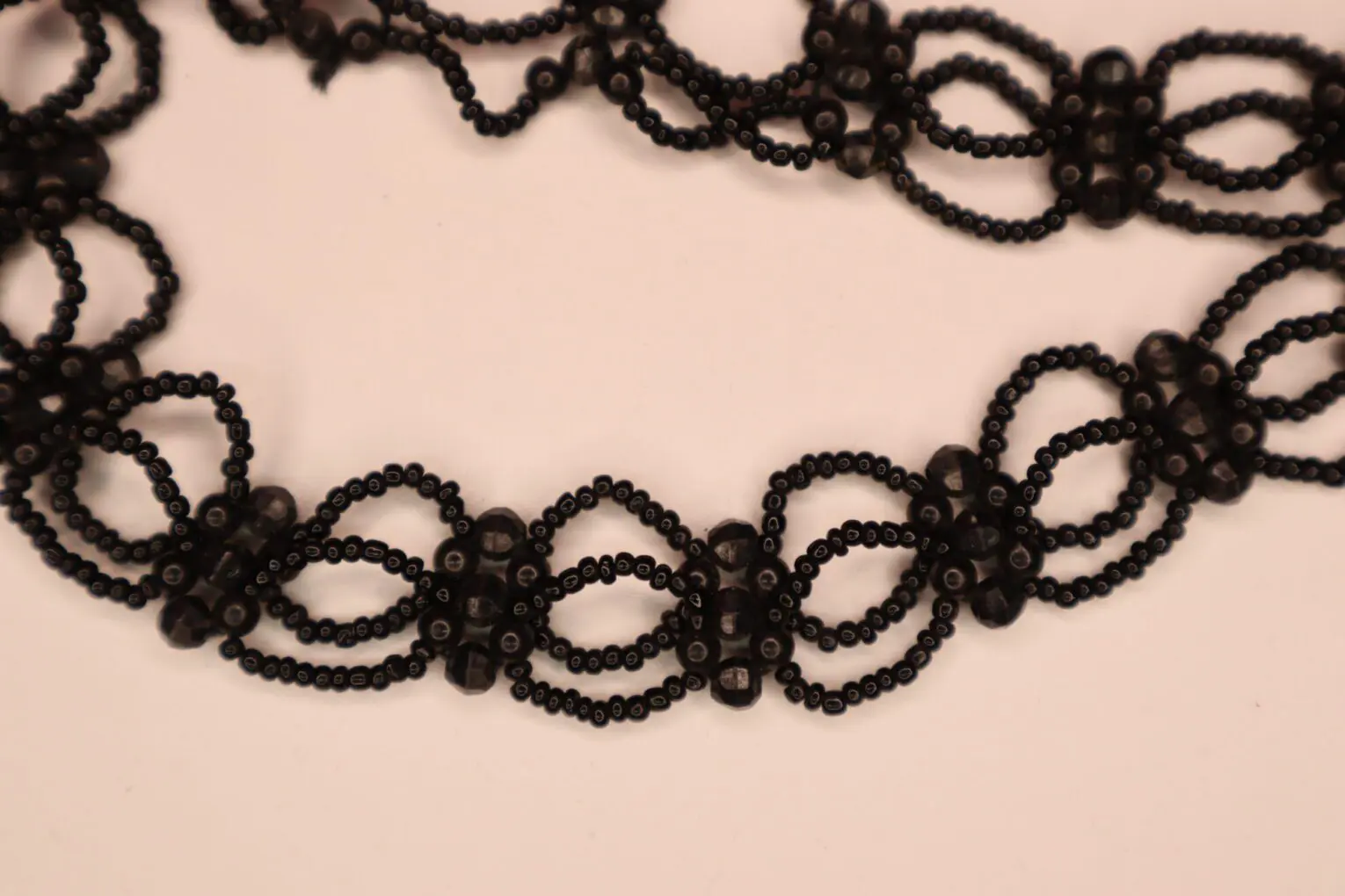 Black beaded necklace with intricate looping design.