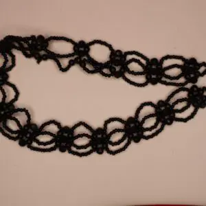 Black beaded necklace with intricate loop design.