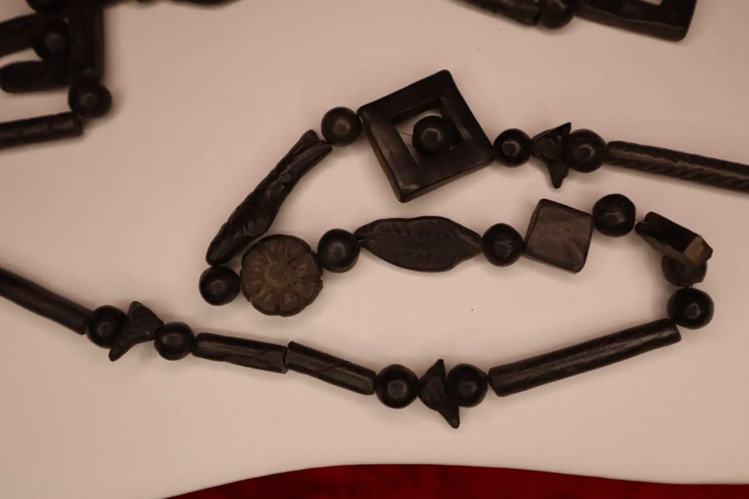 Black beaded necklace with unique shapes displayed.