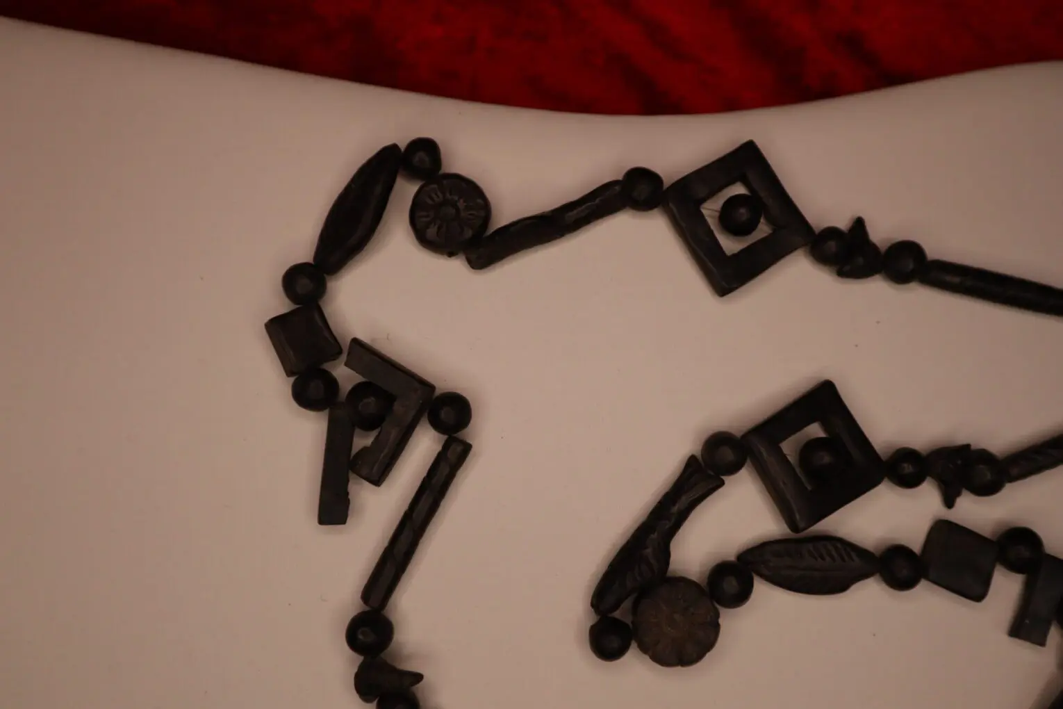Black beaded necklace with geometric shapes displayed.