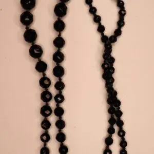Black beaded necklace with varying geometric shapes.
