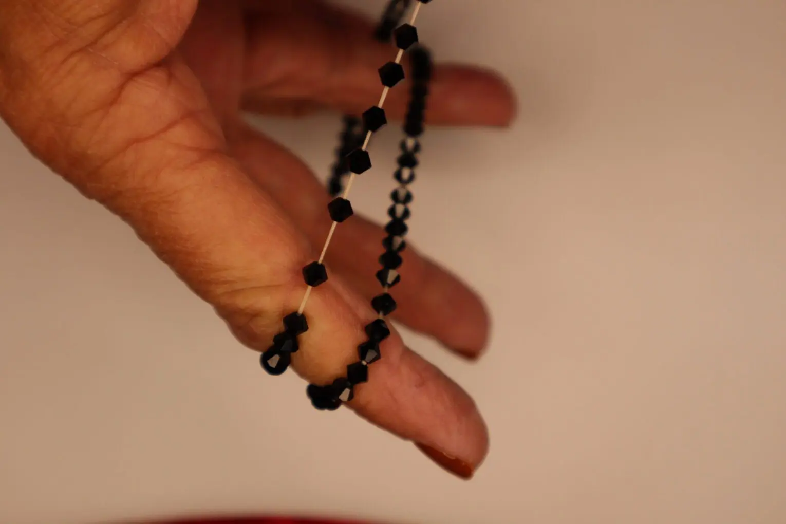 Black hexagonal bead bracelet held in hand.