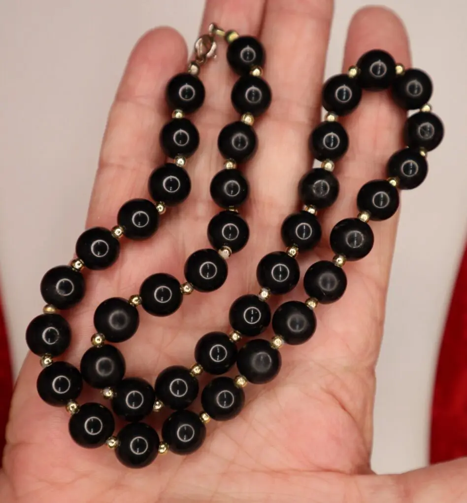 Black beaded necklace with gold accents displayed.
