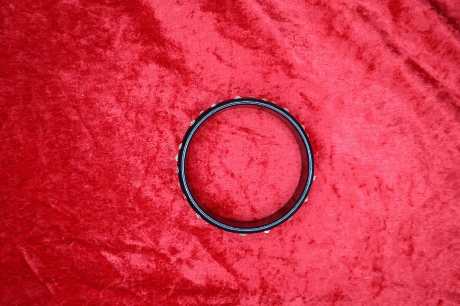 Black bangle bracelet with decorative accents.