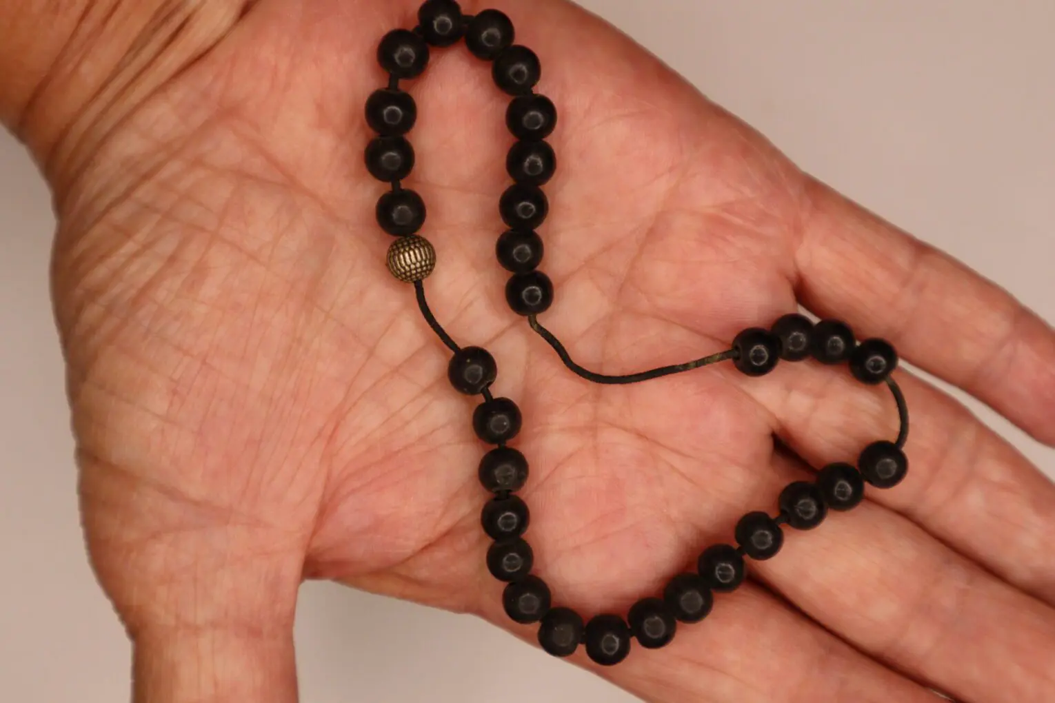 Black beaded necklace shaped like a heart.