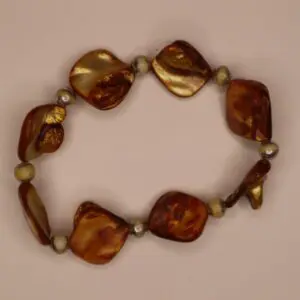 Brown and gold beaded bracelet on light background.