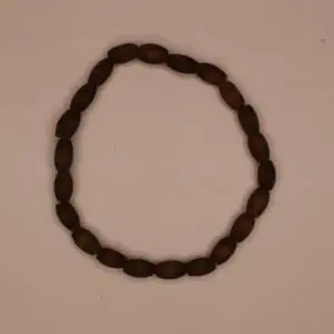 Brown beaded bracelet arranged in circular shape.