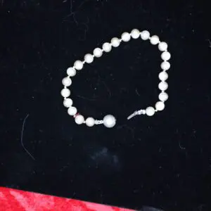 Elegant pearl bracelet on dark velvet background.
