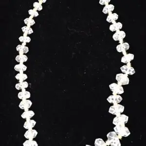 Clear beaded necklace with geometric shapes displayed.
