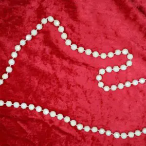 White beaded necklace arranged in a unique shape.