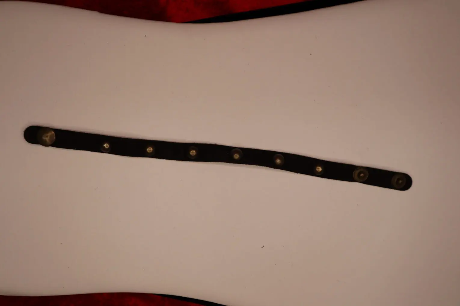 Black leather bracelet with decorative metal snaps.