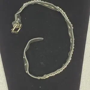 Thin metal bracelet with twisted design.