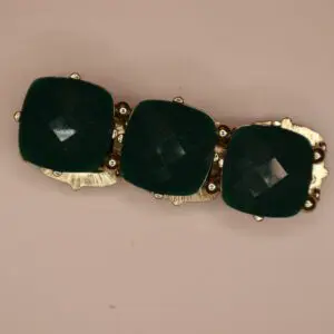 Three green square stones set in gold.