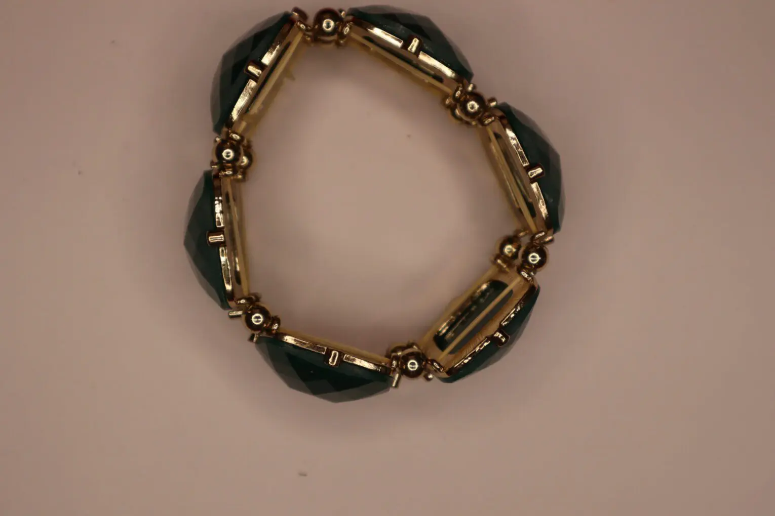 Gold-accented bracelet with green gem details.
