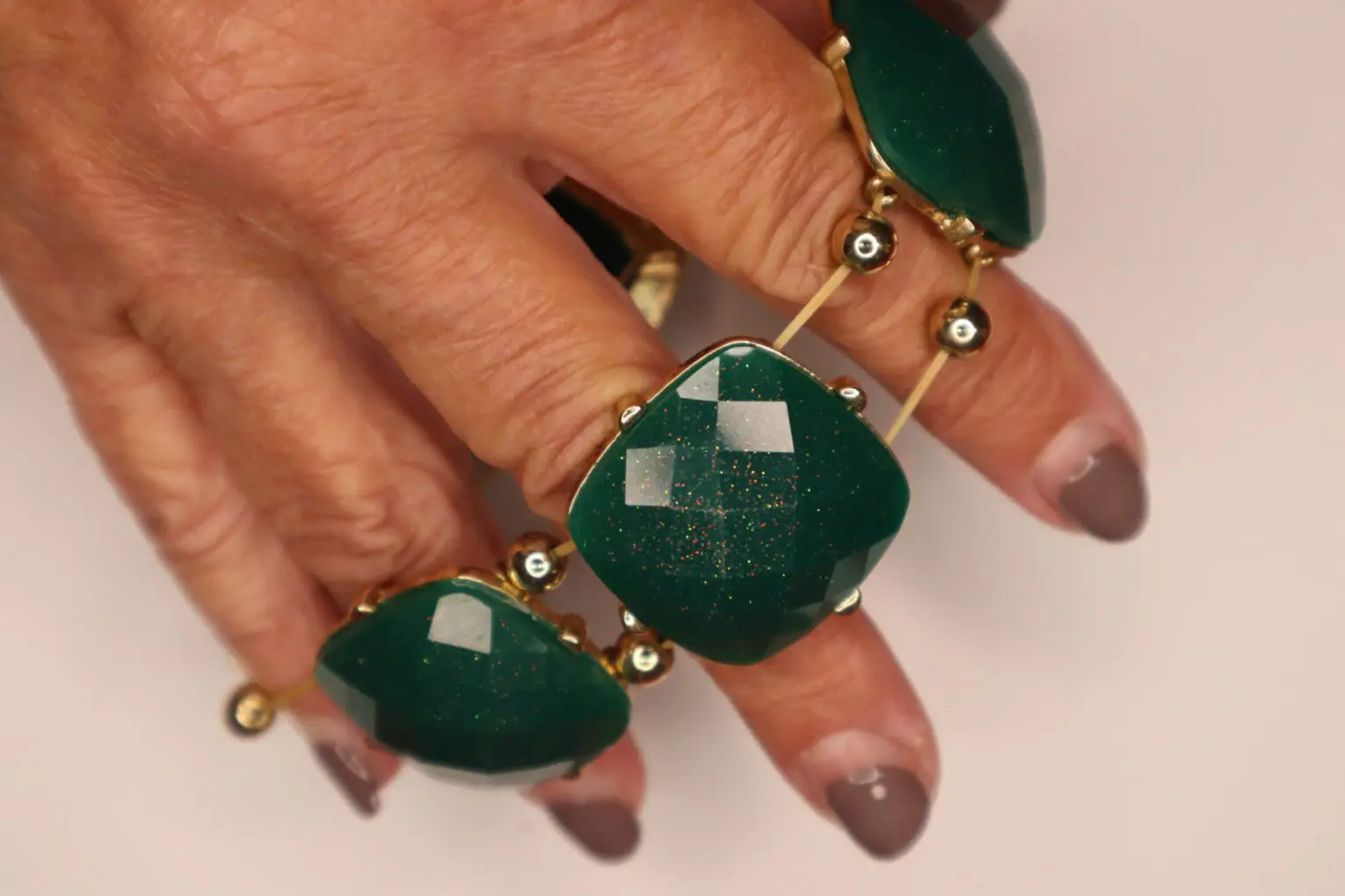 Green gemstone rings with gold accents.