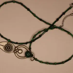 Silver pendant necklace with green bead accents.