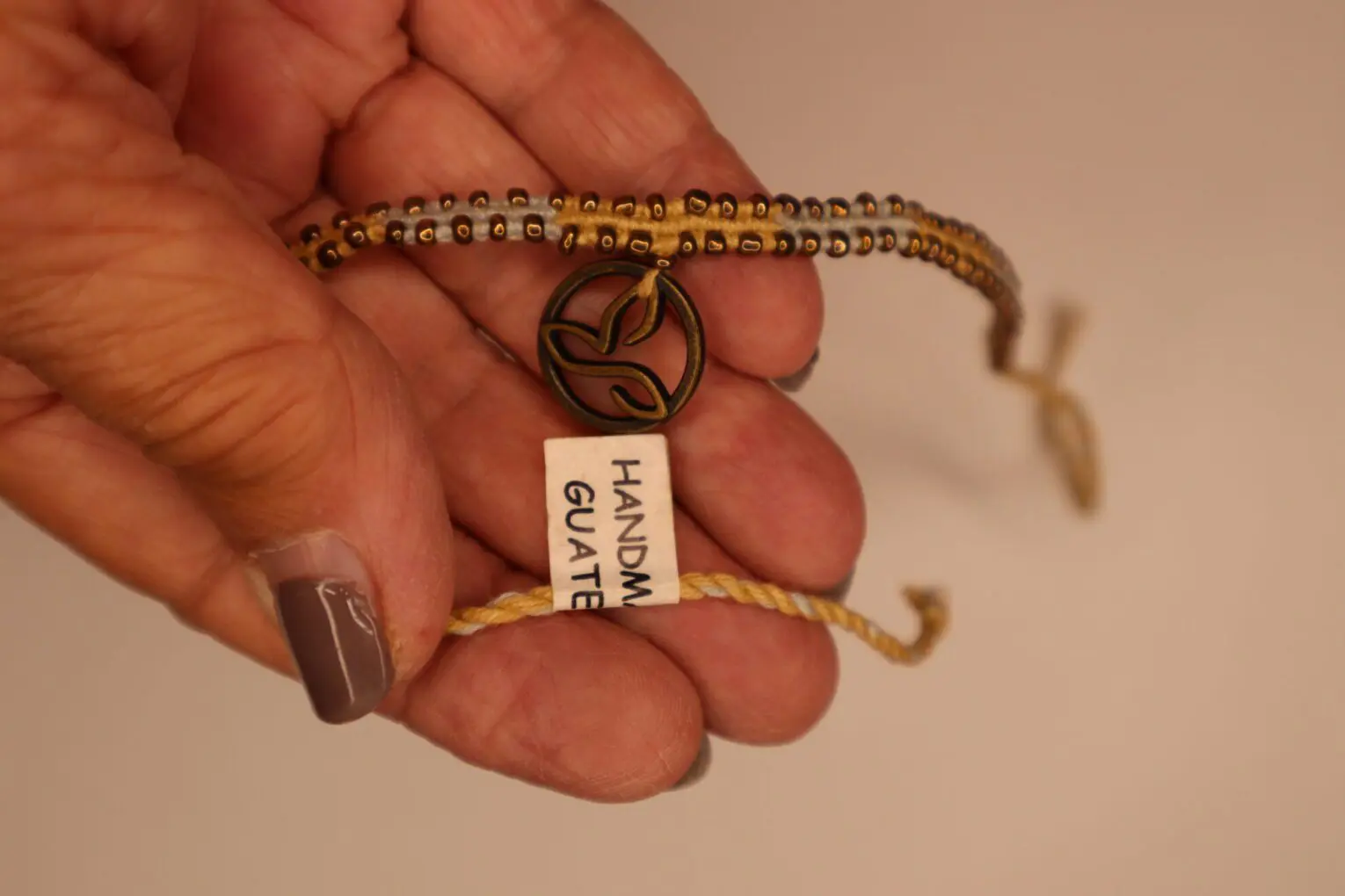 Handmade bracelet with decorative charm and tag.