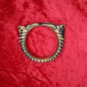 Tiger-striped wooden bracelet on red fabric.