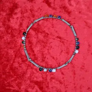 Colorful beaded necklace with silver accents displayed.