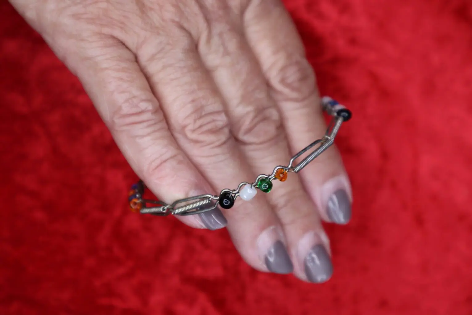 Colorful beaded bracelet held on a hand.