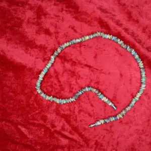 Colorful beaded necklace arranged on red fabric.
