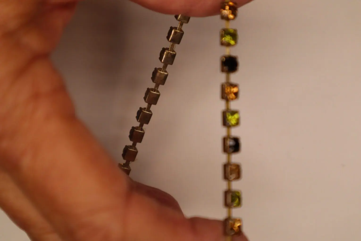 Gold and silver bracelets with square embellishments.