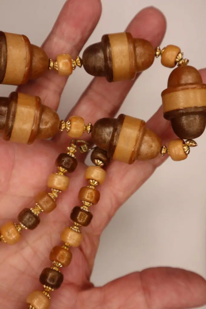 Wooden bead necklace with golden accents displayed.