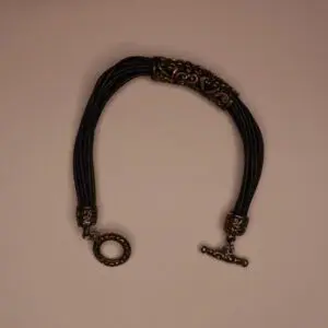 Braided bracelet with decorative metal accents.