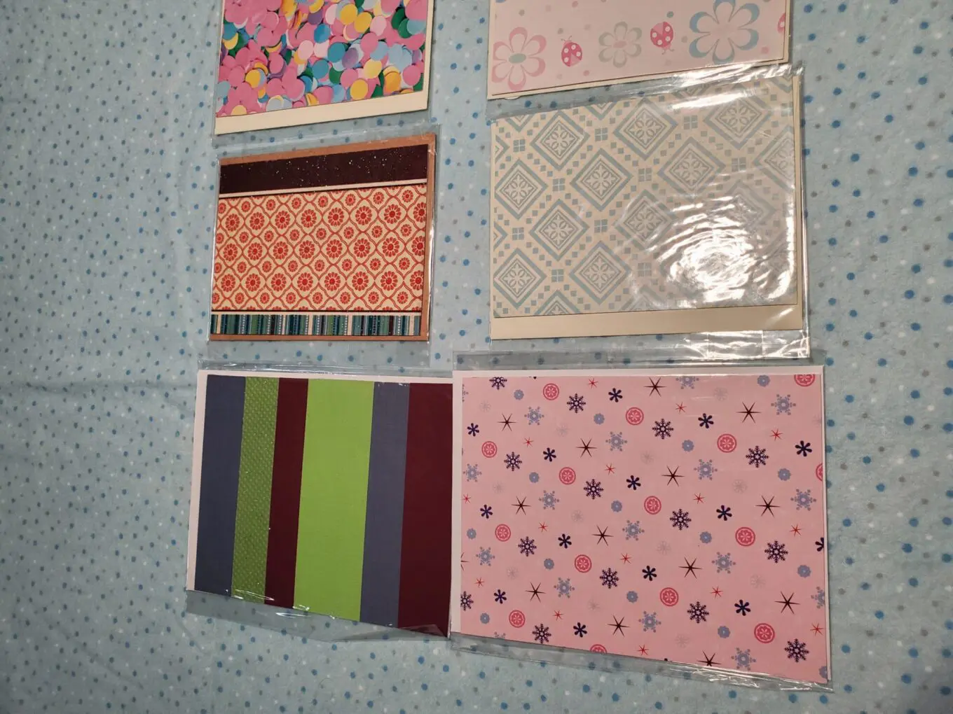 Assorted decorative paper sheets on blue background.