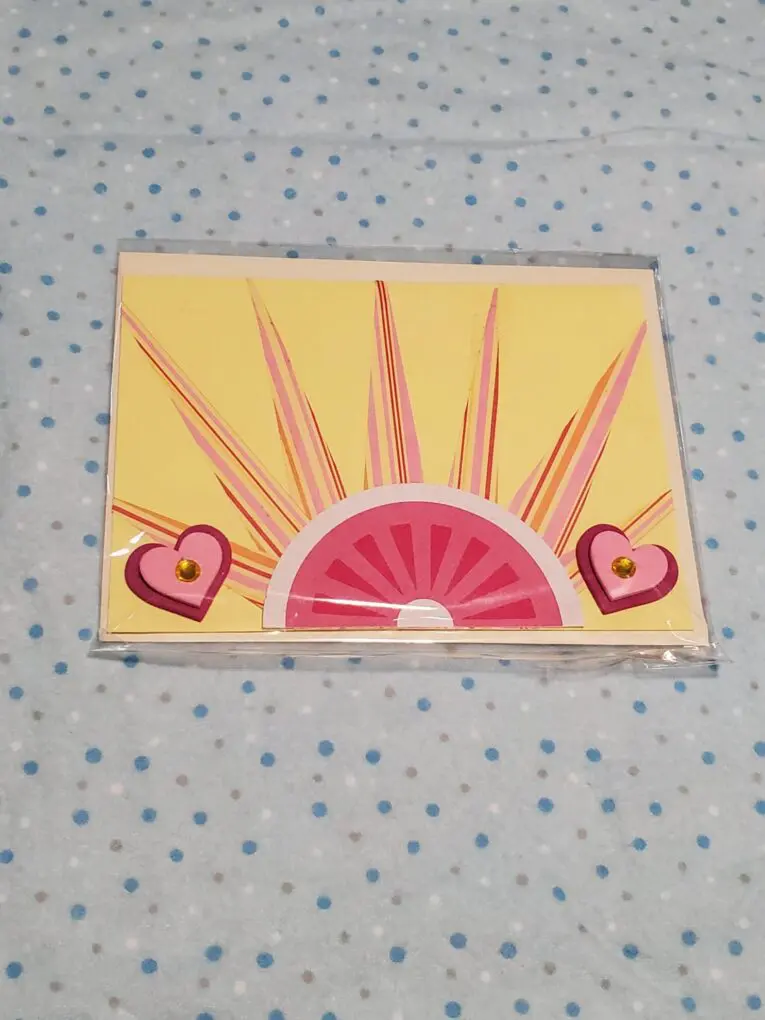Colorful card featuring hearts and sun design.