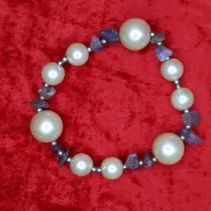 Pearl and amethyst beaded necklace on red background.