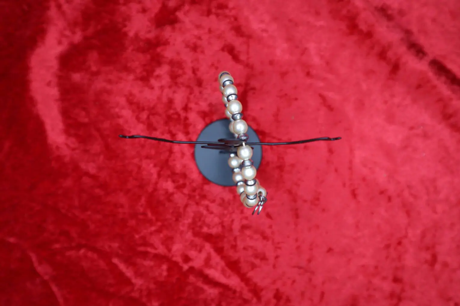 Elegant beaded necklace displayed on a red background.