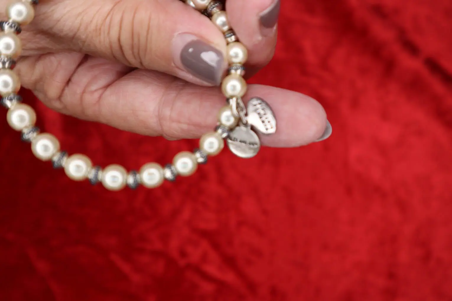 Pearl bracelet with silver accents in hand.