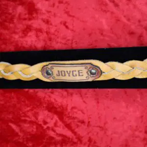 Braided leather bracelet with nameplate detail.
