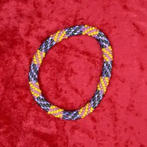 Colorful beaded necklace on a red background.