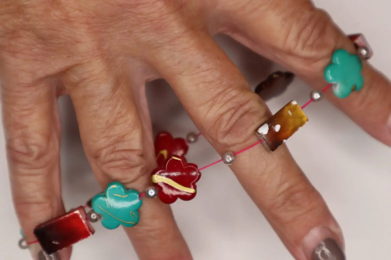 Colorful beaded bracelet with floral-shaped charms.