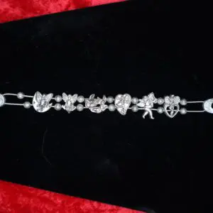 Silver charm bracelet with intricate designs displayed.