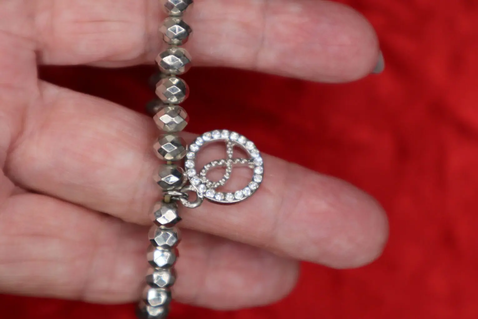 Silver bracelet with peace charm and beads.