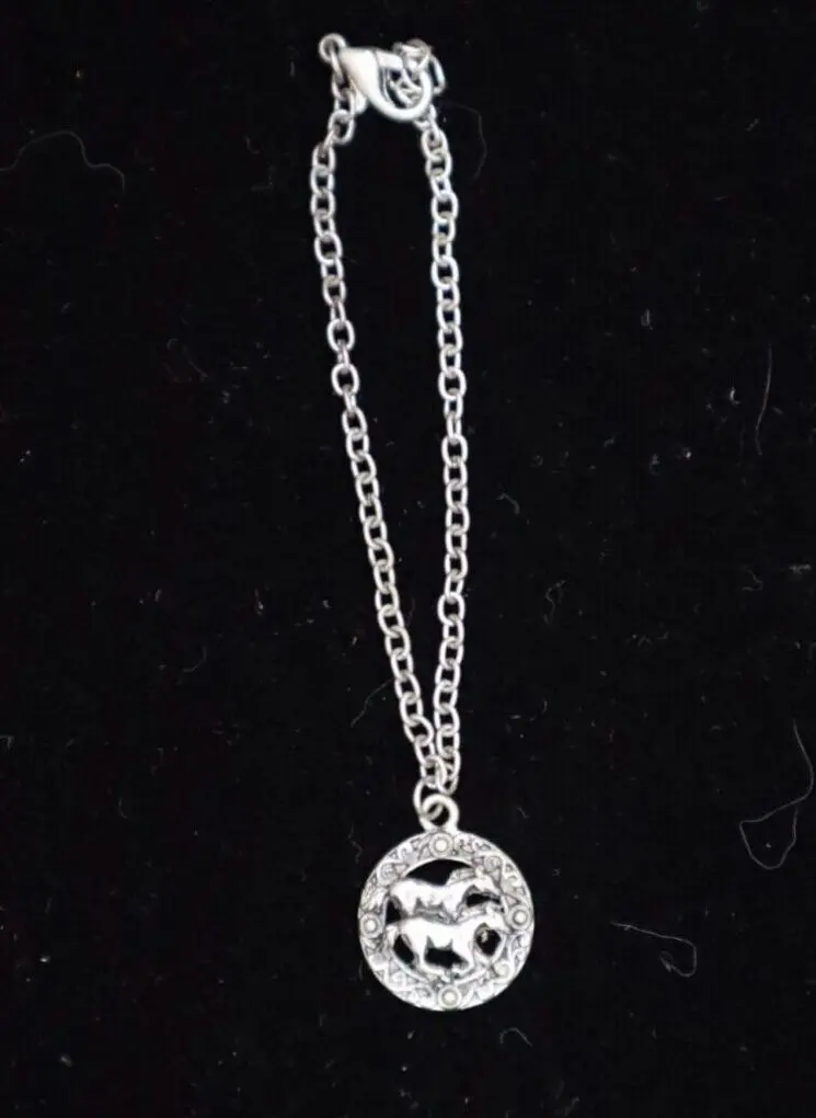Silver necklace featuring a circular animal pendant.