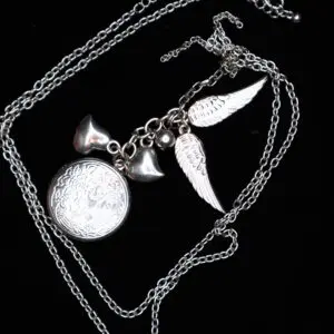 Silver necklace with heart and wing charms.
