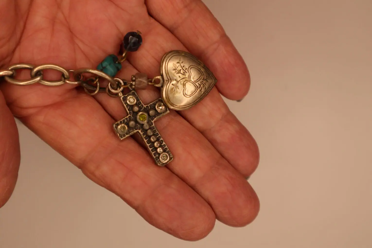 Silver charm bracelet with cross and heart.