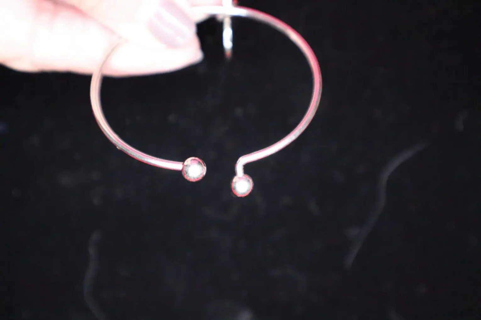 Minimalist silver hoop bracelet with two accents.