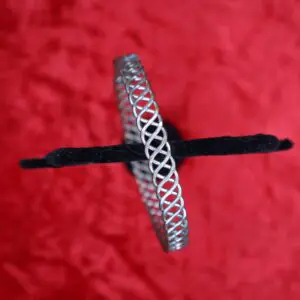 Silver twisted bracelet displayed on a red background.