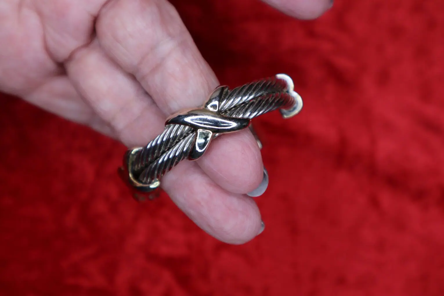 Silver twisted bracelet held in a hand.